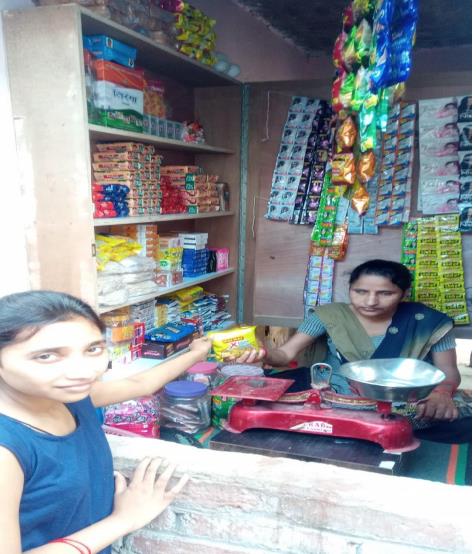 Sridevi sitting in her shop selling biscuit to a little girl